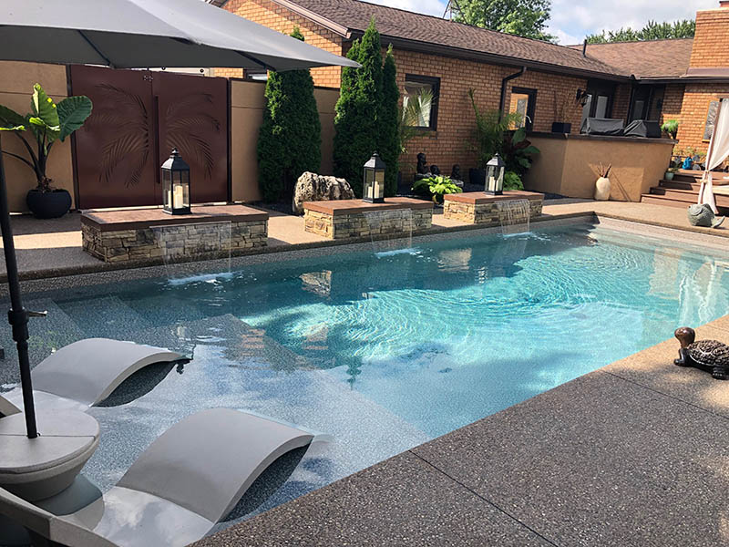 A rectangular pool with built-in tanning ledges in the pool