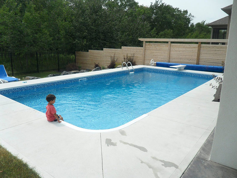 A boy sitting on the edge of a vinyl liner pool
