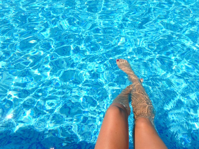 A picture of a person with their legs showing and pool water in front of them